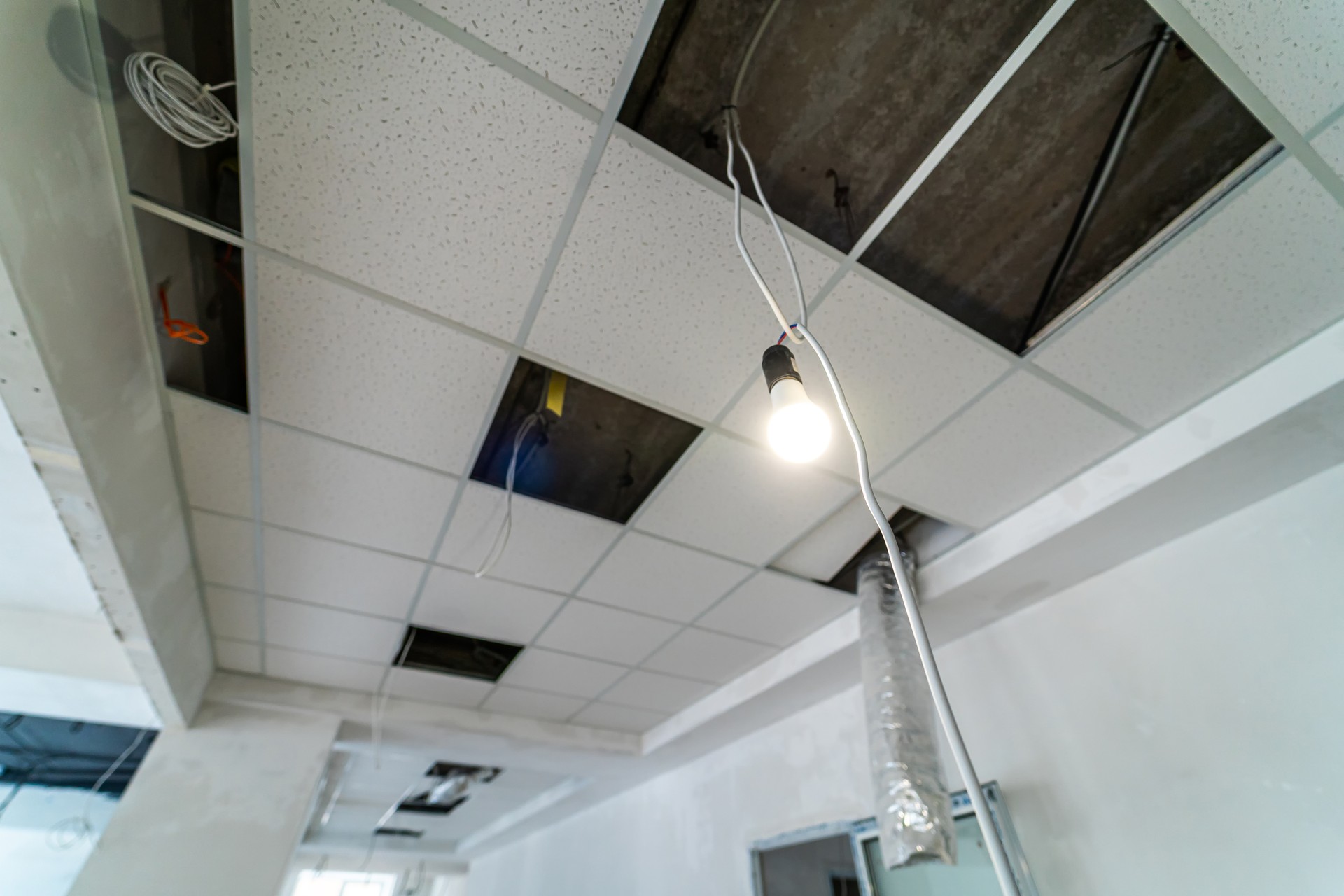 Security and fire alarm on the ceiling in administrative building. Square places for lamps built inside the ceiling