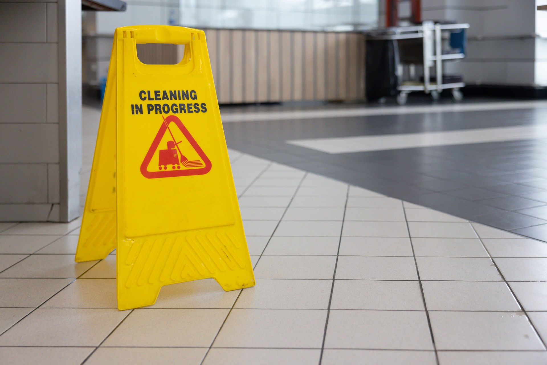 A yellow sign that says "cleaning in progress" is on the floor